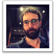 A person with a beard and glasses  Description automatically generated with medium confidence